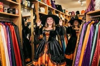 Femme grande taille essayant un costume de sorcière Halloween dans une boutique de déguisements à Paris