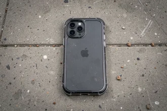 Coque de protection transparente pour iPhone 15 Pro posée sur un trottoir en béton après une chute, vue de dessus